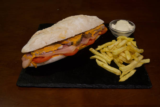 istock A sandwich and fries are on a black plate 2203097120
