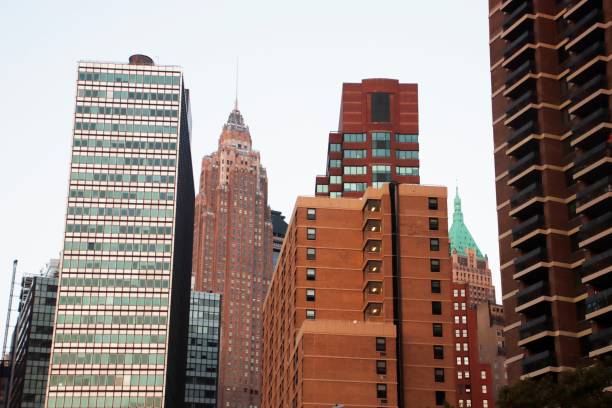 Urban skyline featuring diverse architectural styles of skyscrapers in New York City during daylight.