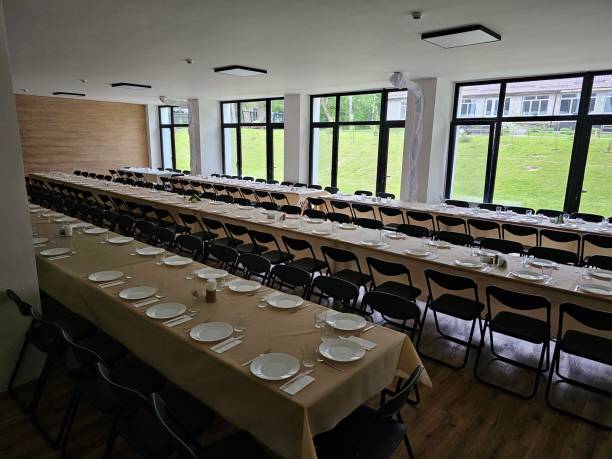 istock Served long table in a large dining room. Cutlery on the table. Wedding table without guests. Hall for ceremonial banquets on the occasion of important events for a large group of people 2203101783