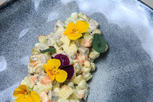 istock a beautifully presented Russian salad, also known as Olivier salad, served on a blue-gray ceramic plate. 2203105471