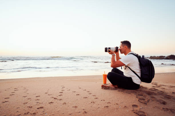 istock Photographer taking pictures on the beach at sunset 2203105800