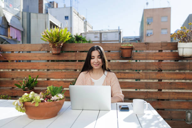 istock Woman enjoying remote work on sunlit terrace 2203106747