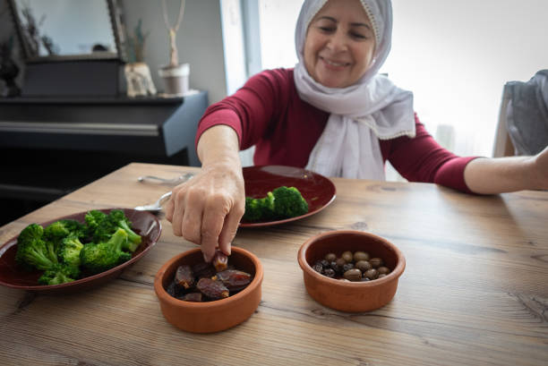 istock Senior Muslim women having Iftar dinner eating dates to break feast 2203107645