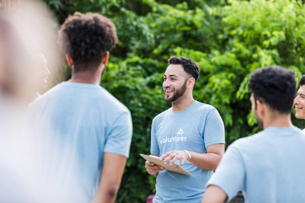 istock Diverse group of volunteers meeting outdoors, smiling and talking 2203108596