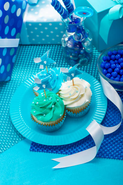 One Year Old Boy Birthday Cupcakes with candy and present decorations on a blue background