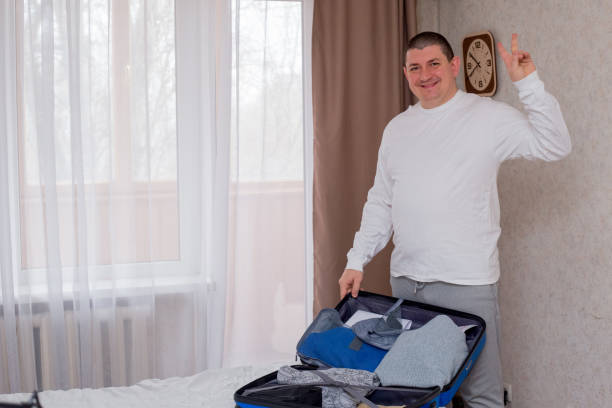 istock Man Packing Suitcase in Hotel Room 2203119234