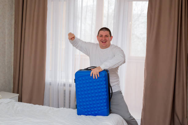 istock Man Packing Suitcase in Hotel Room 2203119250