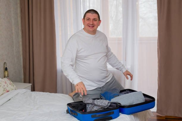 istock Man Packing Suitcase in Hotel Room 2203119253