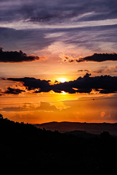 istock Beautiful sunset with clouds in front of the sun and hills below 2203120147