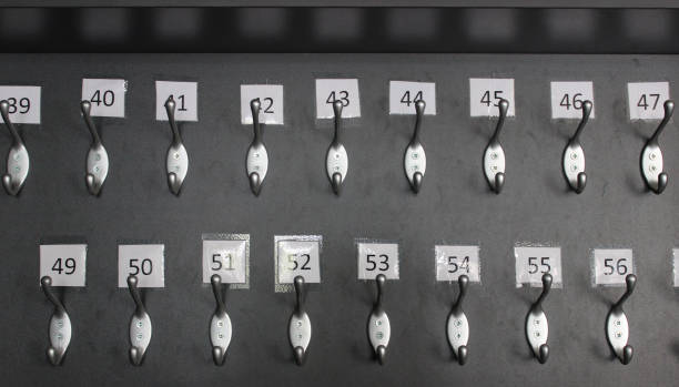 istock Numbered coat hooks on a dark panel in the theater cloakroom 2203124510