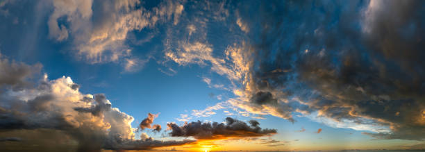 istock Dramatic sunset sky covered with colorful yellow clouds. Panoramic skyscape 2203125234
