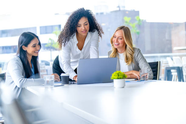 istock Three business  women meeting. They are discussing something while looking at a laptop computer. 2203125282