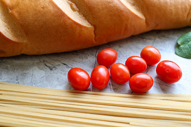 A Loaf Of Italian Bread On A Table With Spaghetti