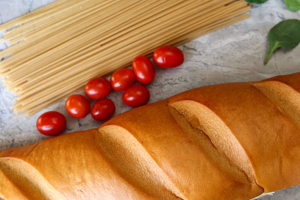 A Loaf Of Italian Bread On A Table With Spaghetti