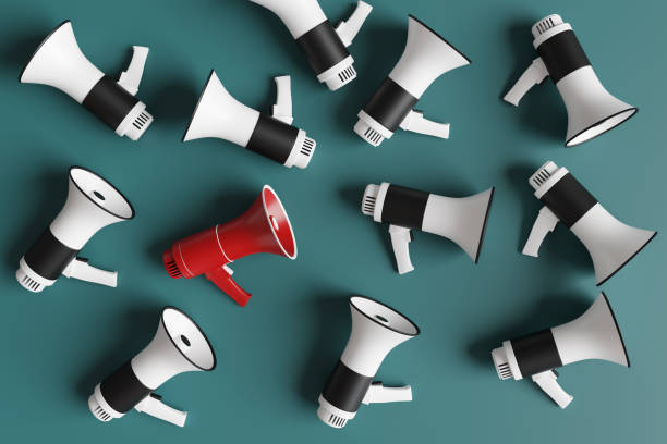 istock Red megaphone among randomly placed black and white megaphones on a green background. Illustration of the concept of announcement, communication and freedom of speech. 2203127514