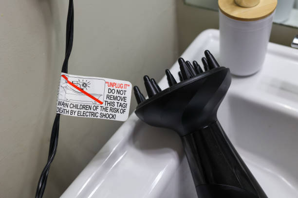 Warning tag on a hairdryer  cord in a bathroom