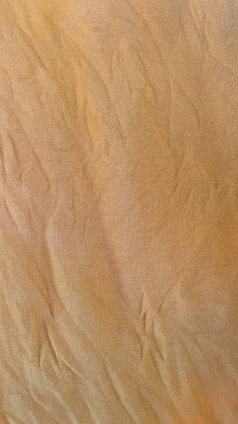 istock Close up of wrinkled yellow fabric texture 2203134198