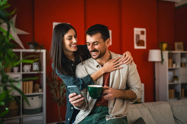 istock romantic couple at affection hug and smile at home while drink coffee 2203134851