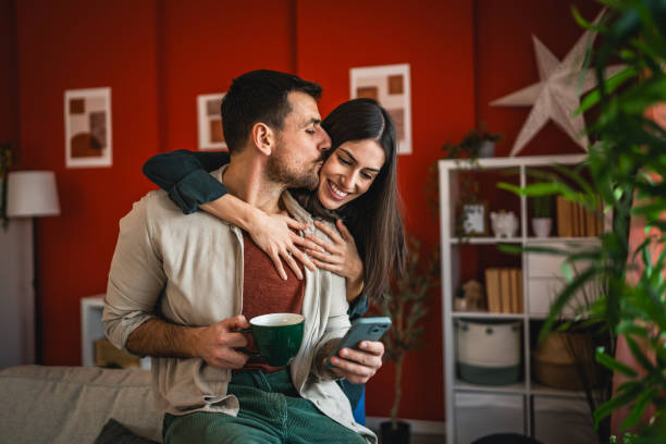 istock romantic couple at affection hug and smile at home while drink coffee 2203135074