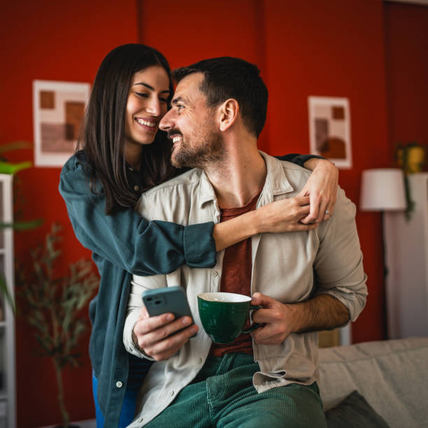 istock romantic couple at affection hug and smile at home while drink coffee 2203135297