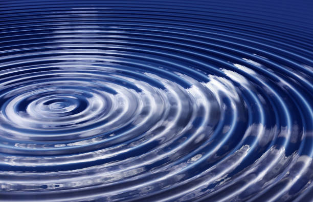 Ripples Reflecting a Clear Blue Sky with White Clouds on a Serene Water Surface