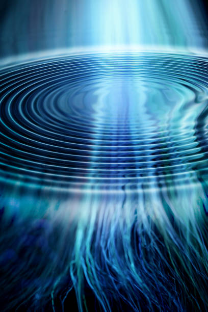 A vibrant abstract image showcasing ripples and waves in blue hues, with light beams cascading downwards. The piece conveys tranquility, fluidity, and the mesmerizing rhythm of water and light interaction.