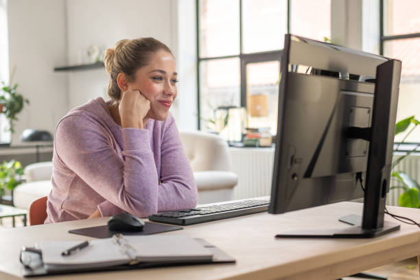istock Young Woman in Purple Sweater Working at Home Office Desktop Computer 2203140280