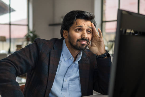 istock Confused Indian Businessman Working on Desktop in Home Office 2203140304