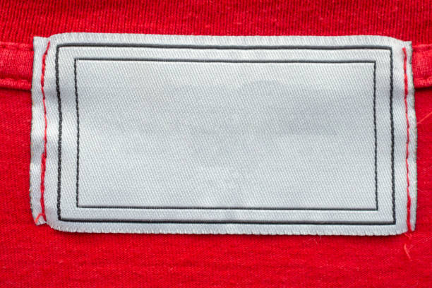 Blank white laundry care clothes label on red shirt fabric texture background
