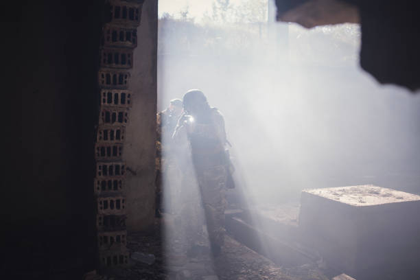 Group of soldiers running from explosion in the building.