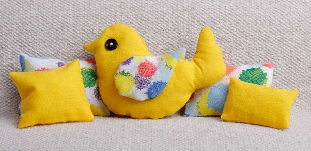 Yellow bird cushion with colorful pillows on a sofa