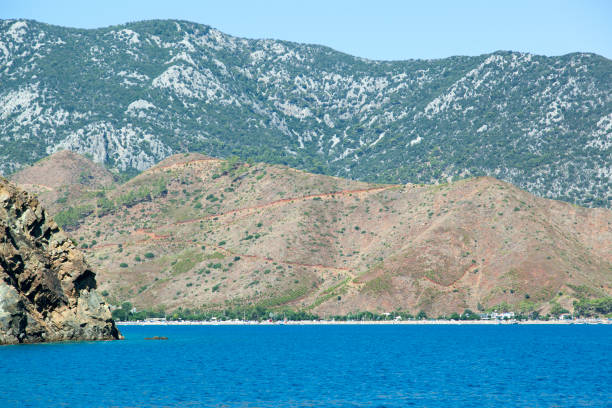 The scenic view of Adrasan resort town along the beach with steep mountains in Antalya province (Turkey).