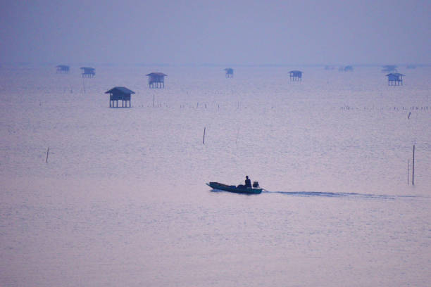 Small boats in the sea with hut of fishermen background