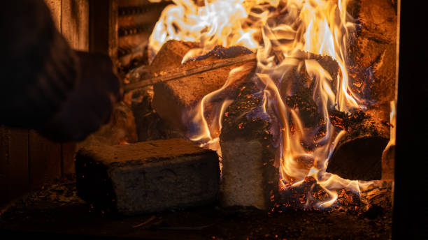 istock Eco-friendly compressed wood briquettes ignite a warm, inviting fire in a modern stove, showcasing sustainable heating and cozy ambiance for any home 2203146251