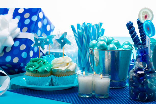 One Year Old Boy Birthday Cupcakes with candy and present decorations on a blue background