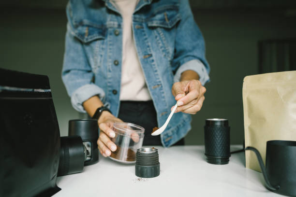 istock prepare of Hand using spoon scooping roasted coffee bean in put equipments brewing coffee potable of small to making drink menu. 2203150182
