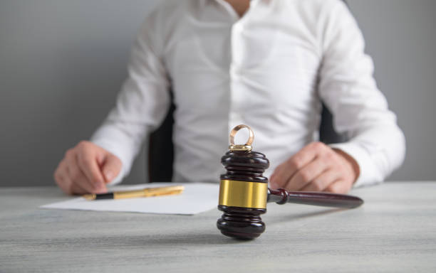 istock Divorce judge with a gavel and wedding rings. 2203150520