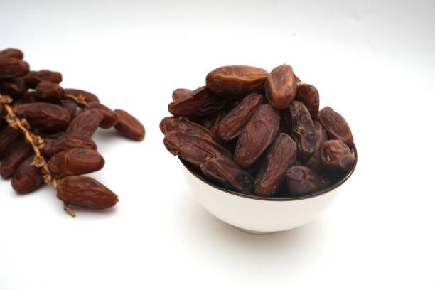 istock Dried dates fruits in ceramic bowl isolated on white background. 2203152475