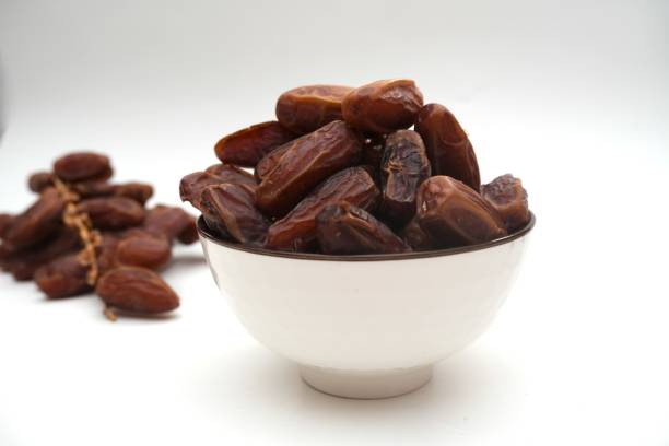 istock Dried dates fruits in ceramic bowl isolated on white background. 2203152478