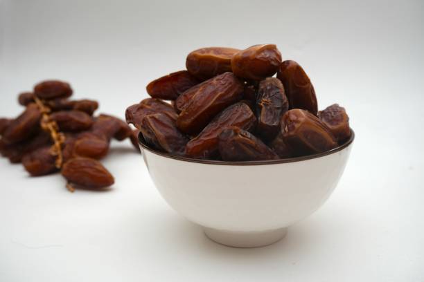 istock Dried dates fruits in ceramic bowl isolated on white background. 2203152490