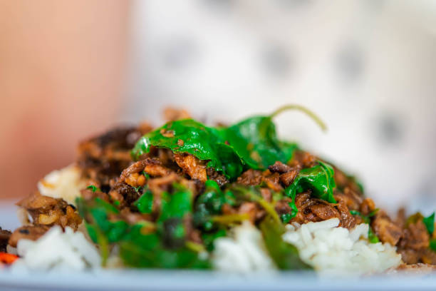 Rice topped with stir-fried pork or beef and basil for sale at Thai street food market or restaurant in Bangkok Thailand