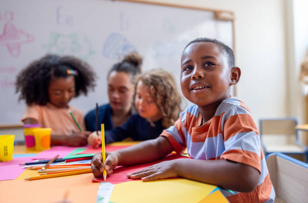 Happy schoolboy drawing in class at the kindergarten
