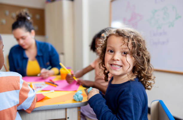 istock Happy schoolboy drawing in class at the kindergarten 2203154711