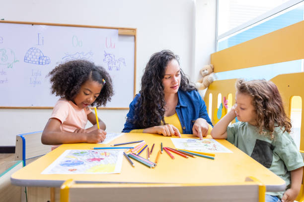 istock Preschool teacher in class with two students 2203154735