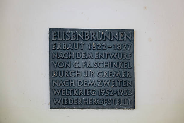 The commemorative plaque at Elisenbrunnen, which highlights the building's construction between 1822 and 1827 by C.F. Schinkel, a neoclassical architect.