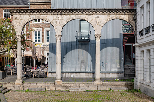 A view of stone arches in the old town, with a modern building behind them, highlighting the contrast of old and new architecture in the heart of Aachen.