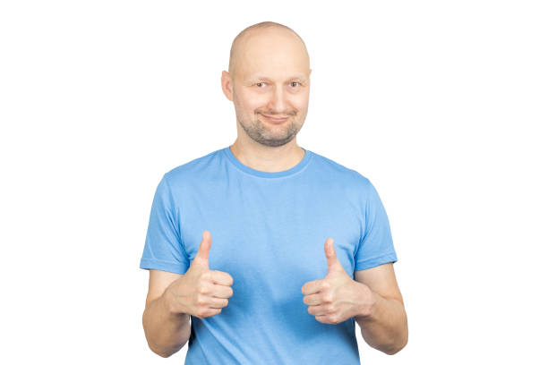 istock Smiling bald man showing thumbs up on white background 2203159485