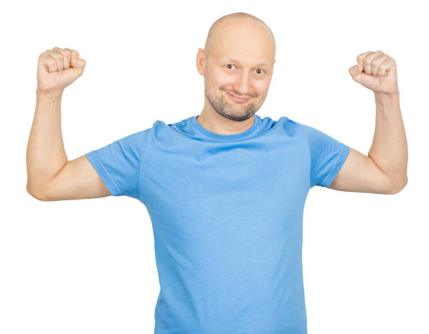 istock Bald man showing strength and smiling proudly: biceps flexing 2203159763