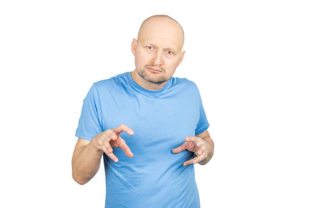 istock Bald man in blue t-shirt making funny and strange grimaces on white background 2203159802