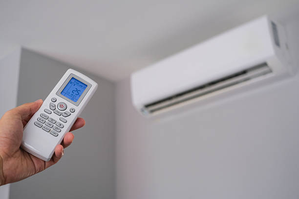 istock Man's hand using remote control open The air conditioner is cooled to 25 degrees Celsius in his bedroom. Health concepts and energy savings 2203162800